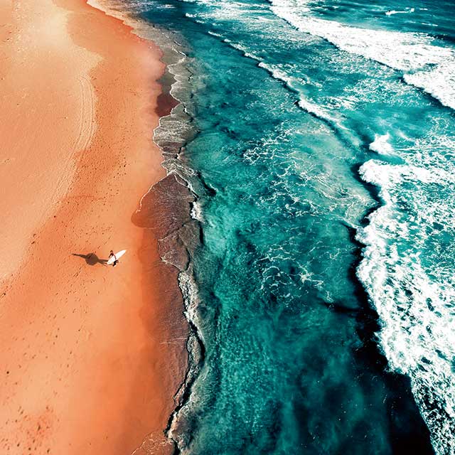 Surfer walking on a beach